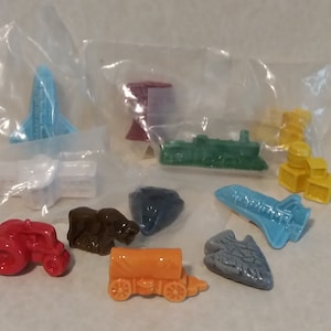 May include: A collection of ten miniature ceramic figurines, each depicting a different mode of transportation. The figurines are in various colors, including red, blue, green, yellow, orange, and brown. The figurines are packaged in individual plastic bags.
