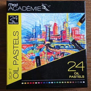 May include: A Mead Académie box containing 24 soft oil pastels. The black packaging features a colorful city illustration, the text 24 OIL PASTELS, and three individual pastel sticks in yellow, green, and blue displayed on the front.