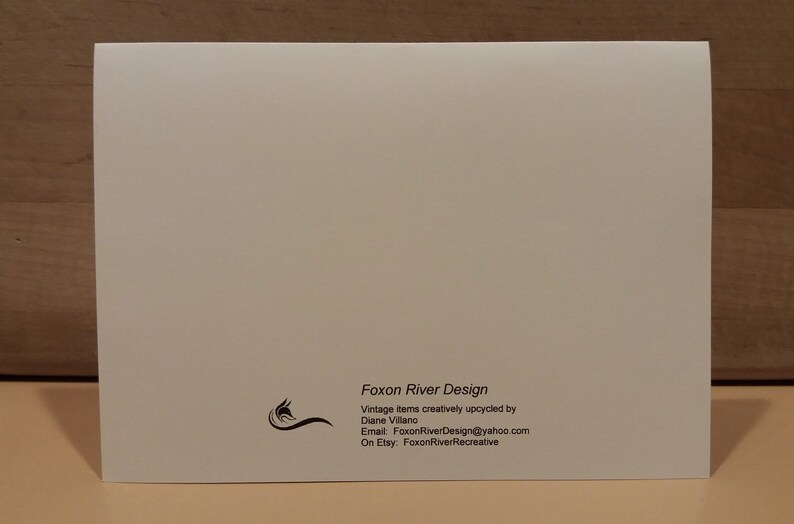 May include: White card with black text that reads "Foxon River Design" and includes contact information for the business. The text reads "Vintage items creatively upcycled by Diane Villano. Email: FoxonRiverDesign@yahoo.com. On Etsy: FoxonRiverRecreative."