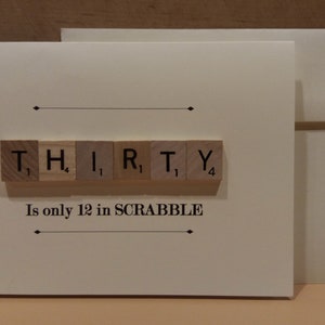 Puede incluir: Una tarjeta blanca con un sobre marr&oacute;n. La tarjeta tiene un fondo blanco con texto negro y una fila de fichas de letras de madera que deletrean "THIRTY". El texto debajo de las fichas dice "Is only 12 in SCRABBLE".