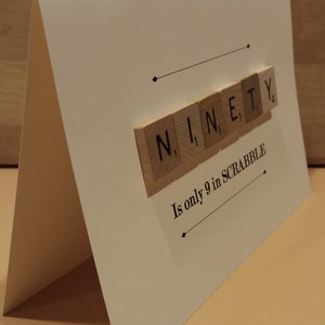 Puede incluir: Una tarjeta blanca con la palabra "NINETY" deletreada con fichas de Scrabble. El texto "Is only 9 in SCRABBLE" est&aacute; impreso debajo de las fichas.