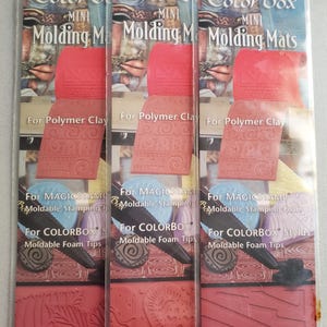 May include: Three packages of ColorBox Mini Molding Mats and accessories for polymer clay. Each package includes molding mats, moldable stamping foam, and moldable foam tips. The packaging features text and various designs.