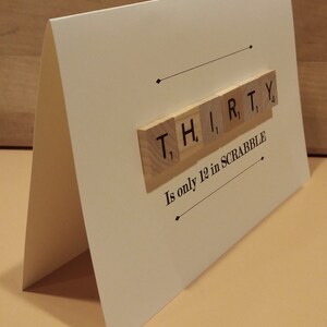 Puede incluir: Una tarjeta blanca con la palabra "THIRTY" deletreada con fichas de Scrabble. La tarjeta dice "Solo vale 12 puntos en SCRABBLE".