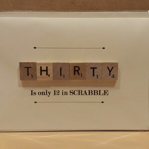 Puede incluir: Una tarjeta blanca con la palabra "THIRTY" deletreada con fichas de Scrabble. Las fichas est&aacute;n dispuestas en una fila y los valores de puntos son visibles. El texto "Is only 12 in SCRABBLE" est&aacute; impreso debajo de las fichas.