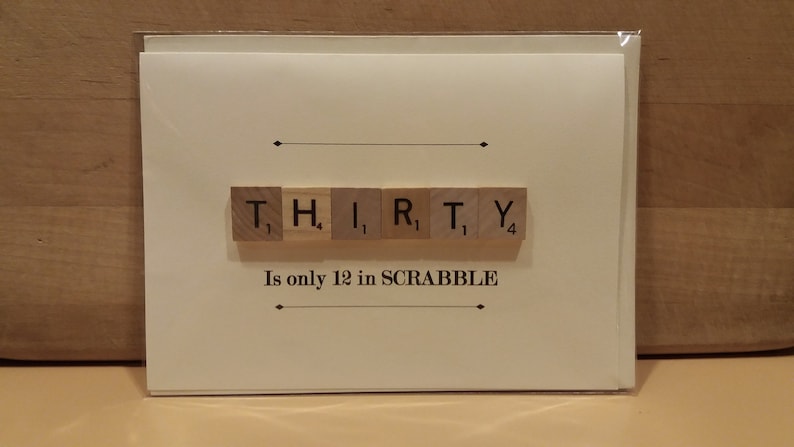 Puede incluir: Una tarjeta blanca con la palabra "THIRTY" deletreada con fichas de Scrabble. Las fichas est&aacute;n dispuestas en una fila y los valores de puntos son visibles. El texto "Is only 12 in SCRABBLE" est&aacute; impreso debajo de las fichas.