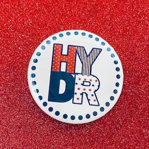 May include: A white button with a red, white, and blue design that says "Happy 4th of July".