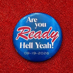May include: A circular blue pinback button featuring the white text Are you, the red script text Ready, the white text Hell Yeah!, and the date 09-19-2026 printed in white at the bottom. The button has a smooth, glossy, and reflective surface.