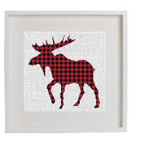 Könnte beinhalten: Ein gerahmter Druck einer roten und schwarzen Buffalo-Plaid-Elch-Silhouette auf weißem Hintergrund.