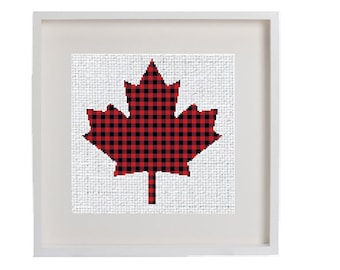 May include: A framed picture of a red and black checked maple leaf on a white background.