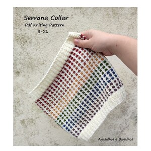 Può includere: Un colletto di maglia bianco con un motivo arcobaleno. Il colletto è realizzato con una maglia testurizzata e ha una leggera lucentezza. Il testo "Serrana Collar" e "Pdf Knitting Pattern" è visibile nell'immagine.
