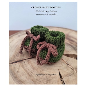 Puede incluir: Un par de botitas de bebé de punto verde y marrón con lazos marrones. Las botitas están sobre una superficie de madera. El texto "CLOVER BABY BOOTIES" y "PDF Knitting Pattern preemie-24 months" está por encima de las botitas. El texto "Agasalhos e Bugalhos" está por debajo de las botitas.