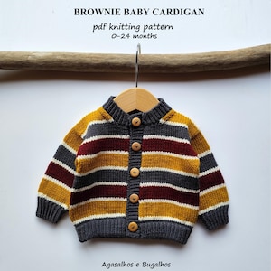 Pode incluir: Um cardigan de bebé tricotado com riscas horizontais em amarelo mostarda, bordô, cinza e branco. O cardigan tem botões de madeira e é exibido em um cabide de madeira. O texto na imagem diz "BROWNIE BABY CARDIGAN pdf knitting pattern 0-24 months".