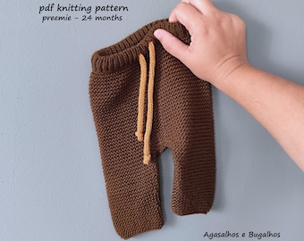 May include: Brown knitted baby trousers with a ribbed waistband and a tan drawstring. The text reads: ESTRELA d'ALVA BABY PANTS, pdf knitting pattern, preemie - 24 months, and Agasalhos e Bugalhos.