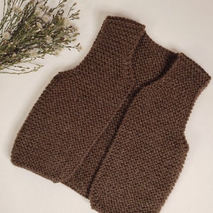 May include: A brown knitted vest with a V-neck.