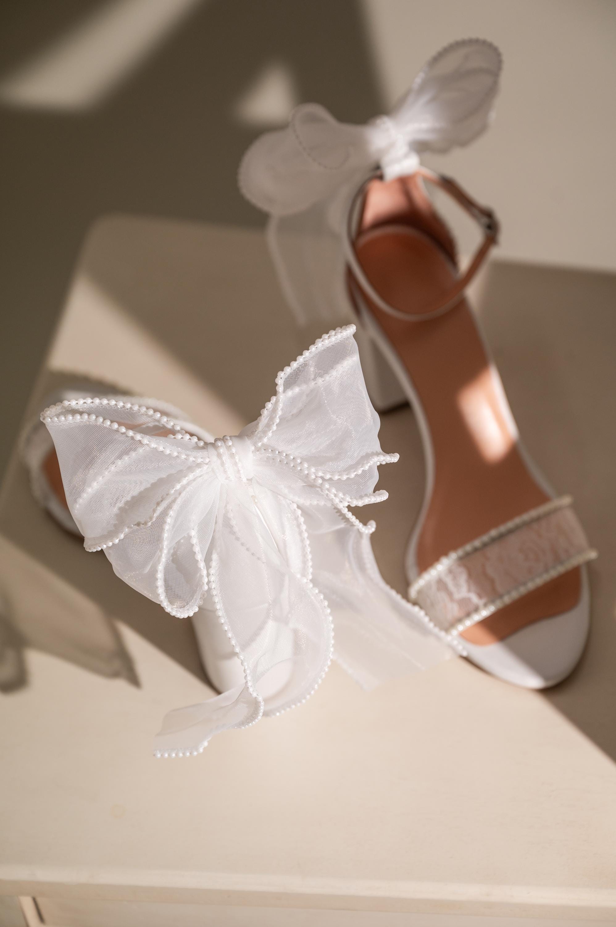 Sandalias blancas de tacón cuadrado con encaje de crochet y lazo