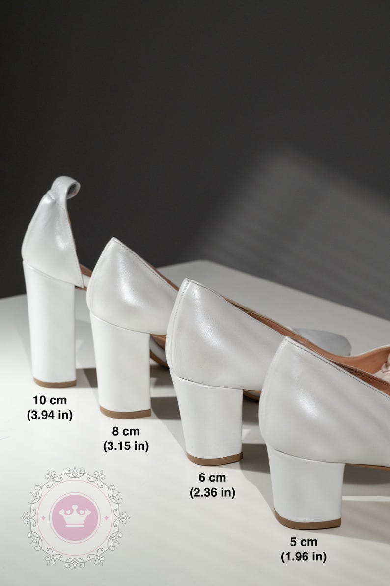 May include: Four pairs of white heeled shoes with different heel heights. The heels measure 3.94 inches, 3.15 inches, 2.36 inches, and 1.96 inches.