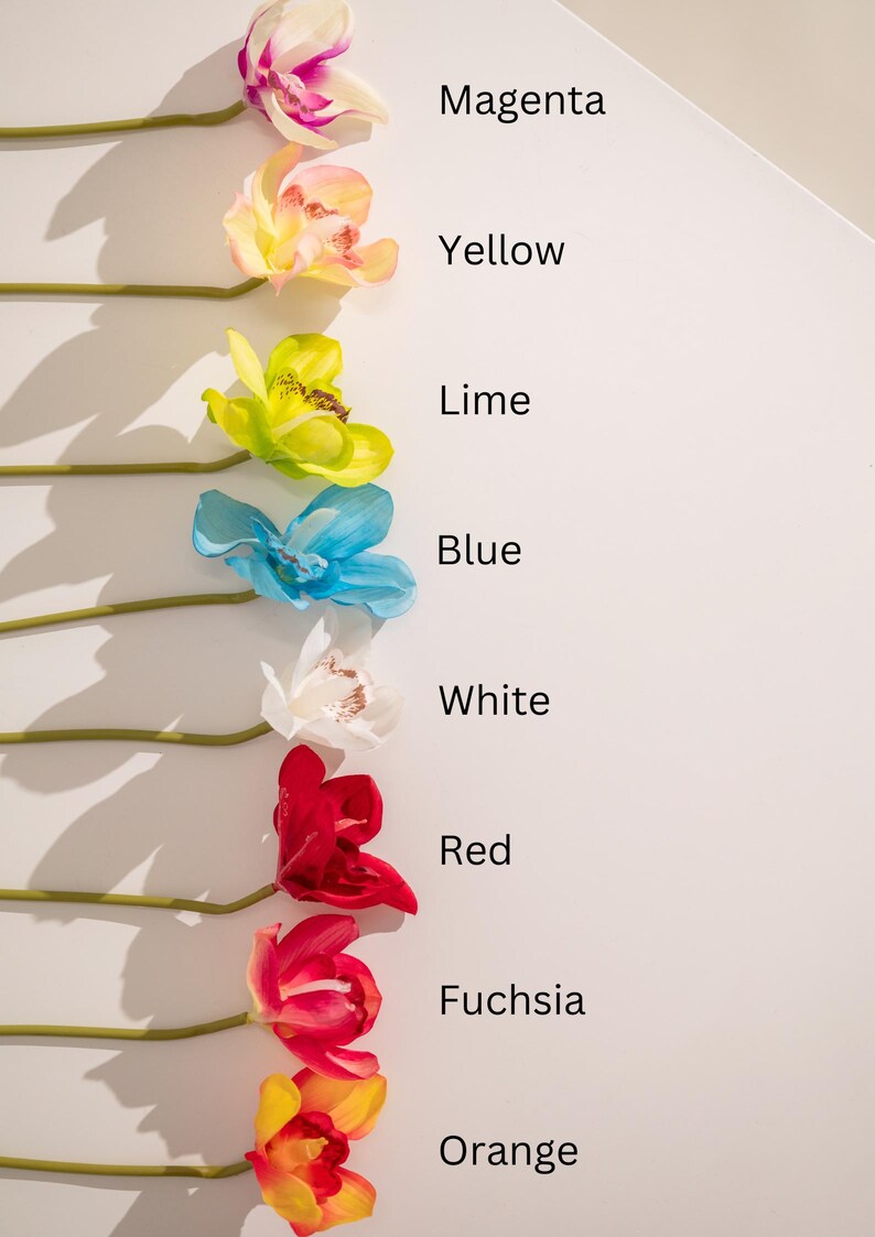A row of artificial orchid stems in various colors, including magenta, yellow, lime, blue, white, red, fuchsia, and orange. Each stem is labeled with its corresponding color name. The image showcases a variety of vibrant hues and the artificial flowers' realistic appearance.