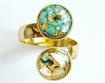 May include: Gold ring with two round turquoise and abalone shell inlays. The ring is a twist design.