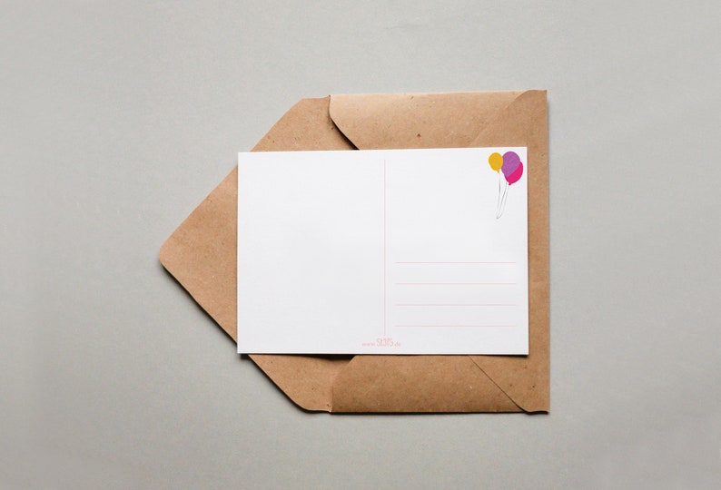 May include: A blank postcard with a brown envelope. The postcard has a light pink and purple balloon illustration in the top right corner.