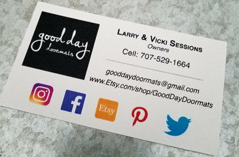 K&ouml;nnte beinhalten: Visitenkarte f&uuml;r Good Day Doormats, ein Unternehmen, das Fu&szlig;matten herstellt. Die Karte zeigt ein schwarz-wei&szlig;es Logo mit dem Text "good day doormats". Die Karte enth&auml;lt auch die Website des Unternehmens, die E-Mail-Adresse, die Telefonnummer und Links zu sozialen Medien. Die Links zu sozialen Medien umfassen Instagram, Facebook, Etsy, Pinterest und Twitter.