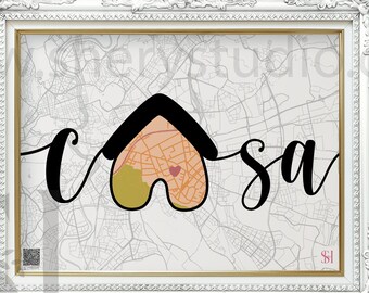 May include: A framed print featuring a map of a city with the word "casa" written in black cursive. The word "casa" is overlaid with a house-shaped graphic in black, pink, and yellow.