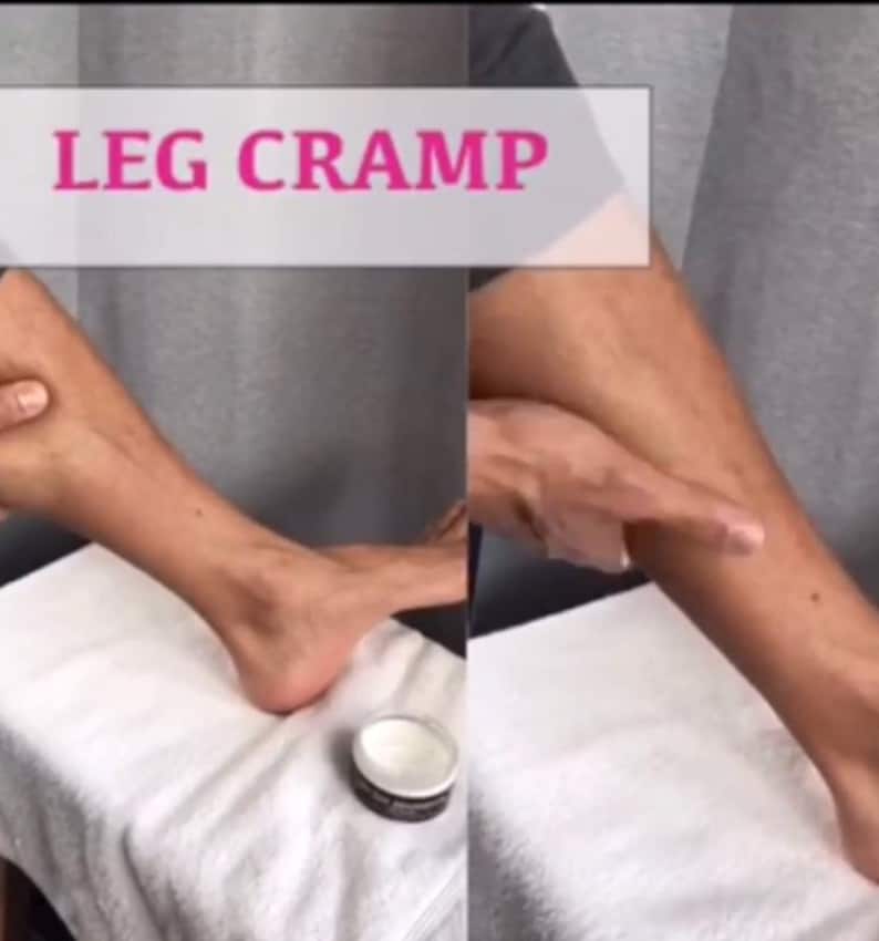 May include: Image shows a person's leg and foot with the text "LEG CRAMP" in a pink box. A small jar of cream sits on a white towel. The image is a demonstration of leg cramp relief.