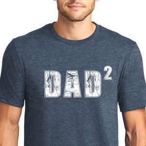 May include: A blue heather t-shirt with the text "DAD²" in white distressed lettering.