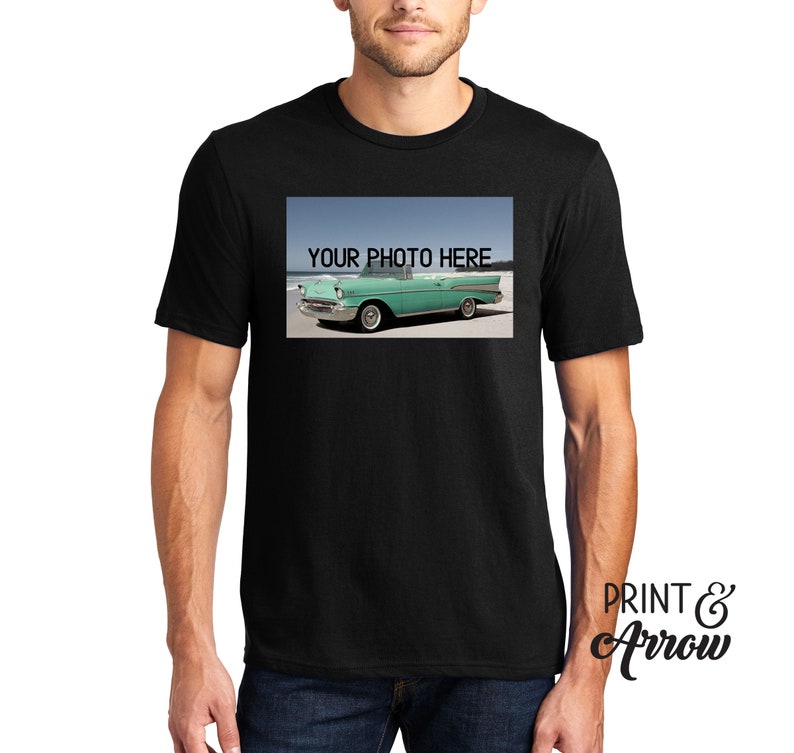 Puede incluir: Una camiseta negra de manga corta con un estampado gr&aacute;fico rectangular en el pecho. El dise&ntilde;o muestra un coche descapotable vintage de color verde claro aparcado en una playa de arena con el texto YOUR PHOTO HERE impreso en negro arriba.