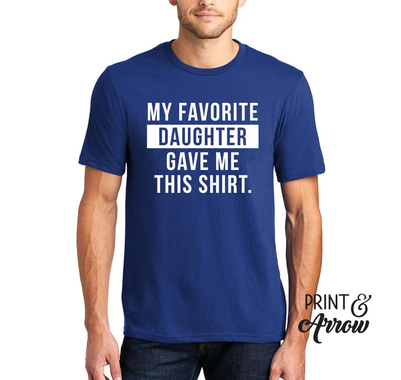K&ouml;nnte beinhalten: Ein k&ouml;nigsblaues T-Shirt mit wei&szlig;em Text, der "Meine Lieblings-Tochter hat mir dieses Shirt geschenkt." lautet.