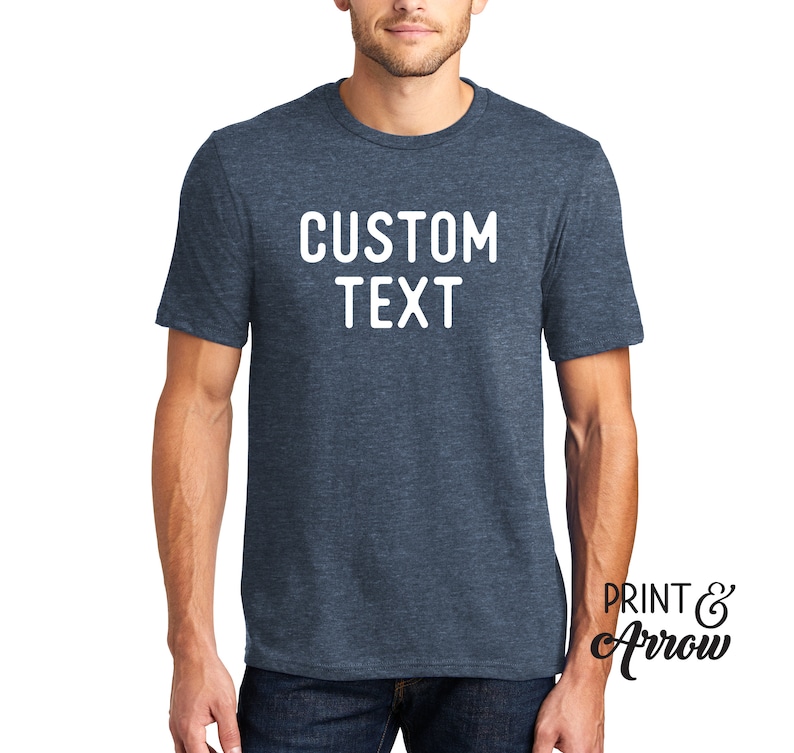 Op de afbeelding: Een blauw heather t-shirt met witte tekst die "CUSTOM TEXT" zegt.