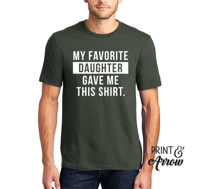 K&ouml;nnte beinhalten: Ein dunkelgr&uuml;nes T-Shirt mit wei&szlig;em Text, der "My Favorite Daughter Gave Me This Shirt." lautet.