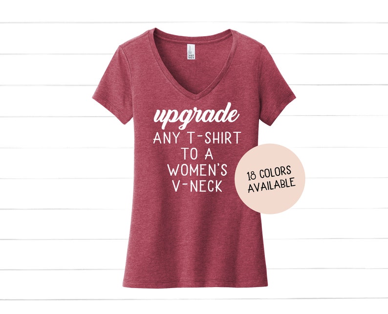 May include: Red V-neck t-shirt with the text "upgrade any t-shirt to a women's v-neck" in white. A pink circle with the text "18 colors available" is in the lower right corner.