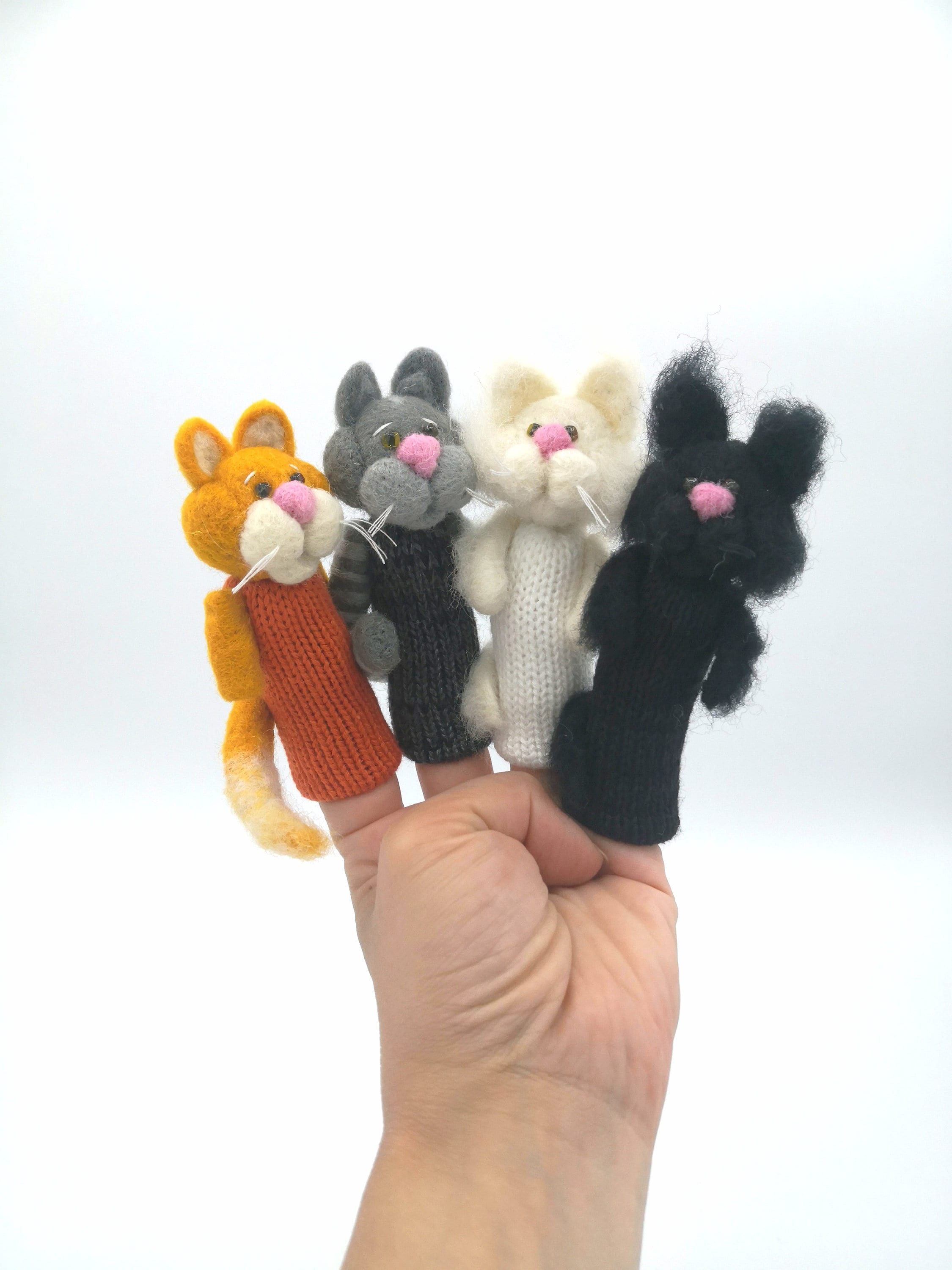 4 gatos pequeños los títeres con dedos en lana de fieltro.