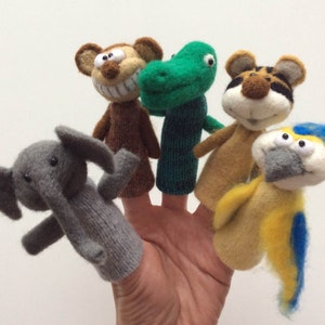 May include: Five felt finger puppets, each depicting a different animal: a monkey, a dinosaur, a tiger, an elephant, and a parrot. The puppets are all brightly colored and have friendly faces.