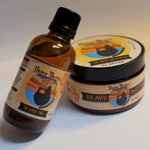 May include: Two bottles of beard care products. A brown glass bottle with a black cap labeled "Urban Beard" and "Beard Oil 2 oz". A black jar with a yellow and orange label that says "Urban Beard Beard Butter All Natural OG Size".