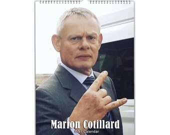 May include: A black and white photo of a man in a suit and tie, making a rock and roll hand gesture. The text "Marion Cotillard Wall Calendar" is below the image.