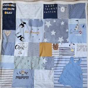 Könnte beinhalten: Eine Patchwork-Babydecke mit verschiedenen Stoffquadraten in Blau, Weiß und Gelb. Einige Quadrate zeigen Texte wie "GOOD THINGS HAPPEN" und "I LOVE MY MUMMY". Andere Quadrate haben Sterne, Bären und Segelboot-Designs.