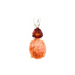 May include: A pendant featuring a round, orange-red gemstone with a smaller, triangular, red gemstone on top. The pendant is made of gold and silver.