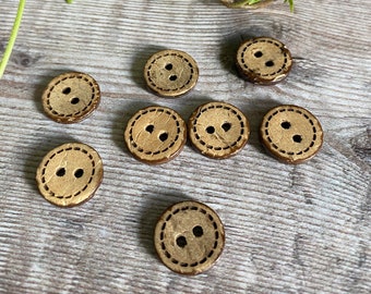 Könnte beinhalten: Acht braune Holzknöpfe mit jeweils zwei Löchern. Die Knöpfe haben einen genähten Rand und eine hellbraune Mitte.