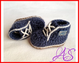 May include: A pair of blue crocheted baby booties with white laces and brown soles.