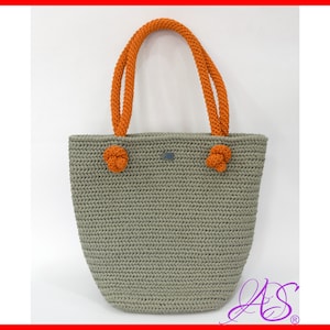 May include: A gray crocheted tote bag with orange rope handles. The bag has a slightly rounded bottom and a rectangular top.