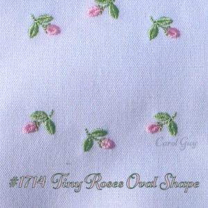 Puede incluir: Primer plano de una tela azul claro con pequeñas rosas rosas bordadas y hojas verdes. El texto "#1714 Tiny Roses Oval Shape" está escrito en una fuente de escritura. El diseño presenta cinco pequeños grupos florales.