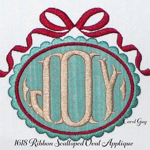 May include: Embroidered applique design featuring the word "JOY" in a cream color, surrounded by a scalloped oval with a teal blue background and a red border. A red ribbon with a bow is placed above the oval.