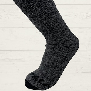 May include: A pair of black thermal socks with a textured knit pattern. The socks are made of a soft, warm material and are perfect for cold weather.