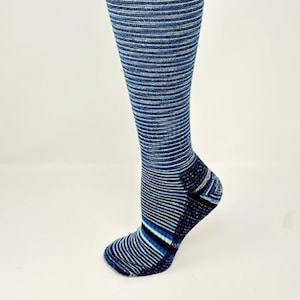 May include: Blue and white striped knee-high compression socks with a textured pattern on the heel and toe.