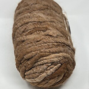 May include: A skein of brown and beige chunky yarn with a fuzzy texture.