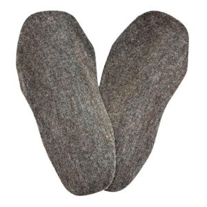 May include: A pair of gray wool felt insoles. The insoles are shaped to fit the foot, with a rounded toe and a contoured heel. The material appears to be thick and dense, providing cushioning and warmth.
