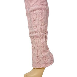 May include: A single light pink cable knit leg warmer. The leg warmer is made of a soft, textured material and has a ribbed cuff at the top. The leg warmer is designed to be worn over the calf and ankle.