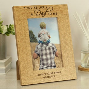 May include: A wooden photo frame with a light brown finish. The frame has a photo of a child on a man's shoulders. The text on the frame reads "You're like a Dad to me" and "Lots of love from George X".