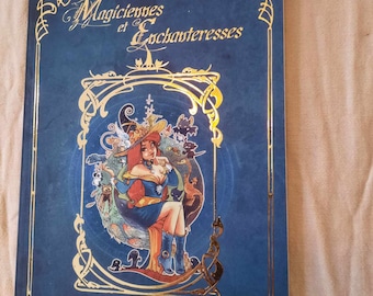 May include: A blue book with a gold border and a gold illustration of a woman with a hat and a cat. The title of the book is "Magiciènnes et Enchanteresses" and the author is "Mod Serrière".